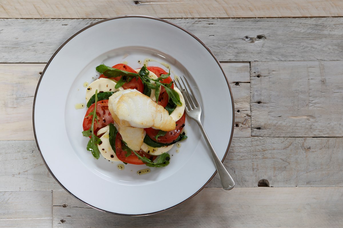 Pan-fried cod on a bed of mozzarella-tomato salad